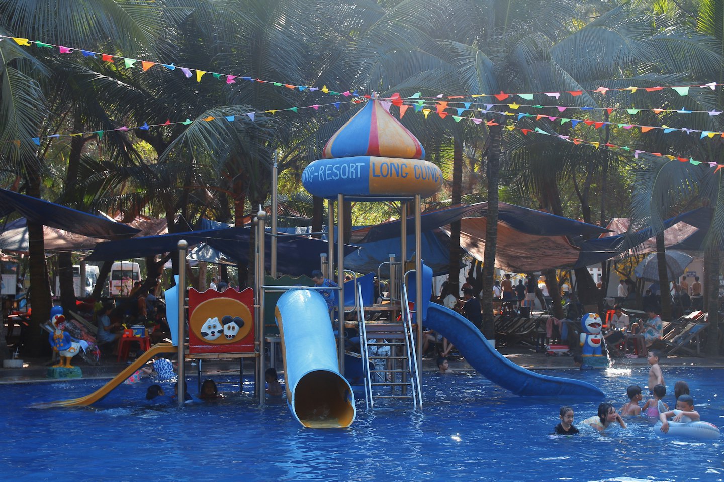 Children play at a resort water park with slides.